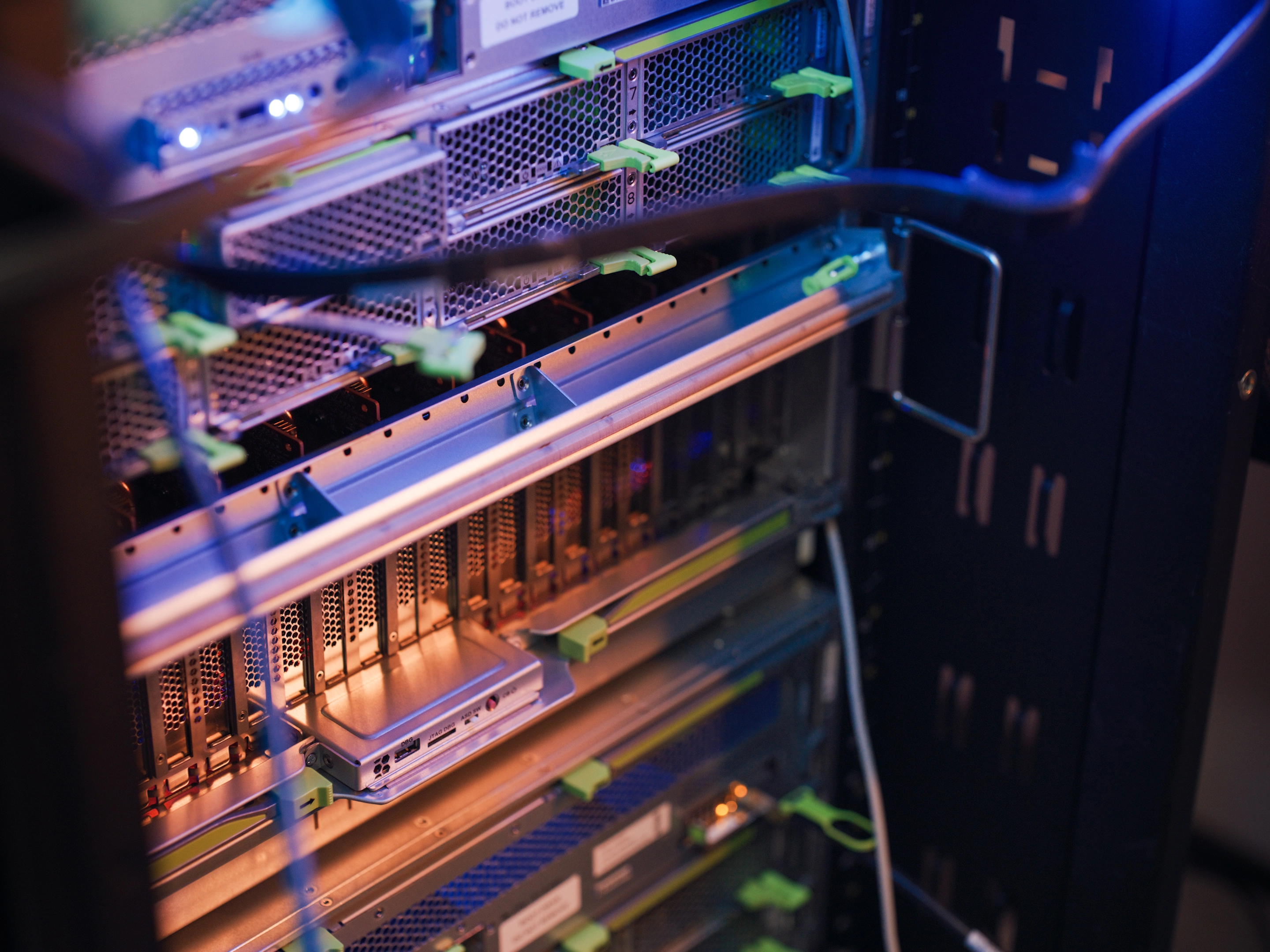Close-up of a server rack with internal components and blue lighting.